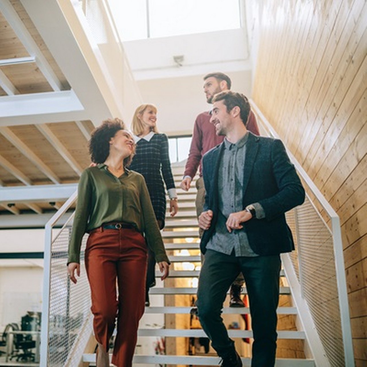Ein diverses Team von Geschäftsleuten geht gemeinsam die Treppe hinunter